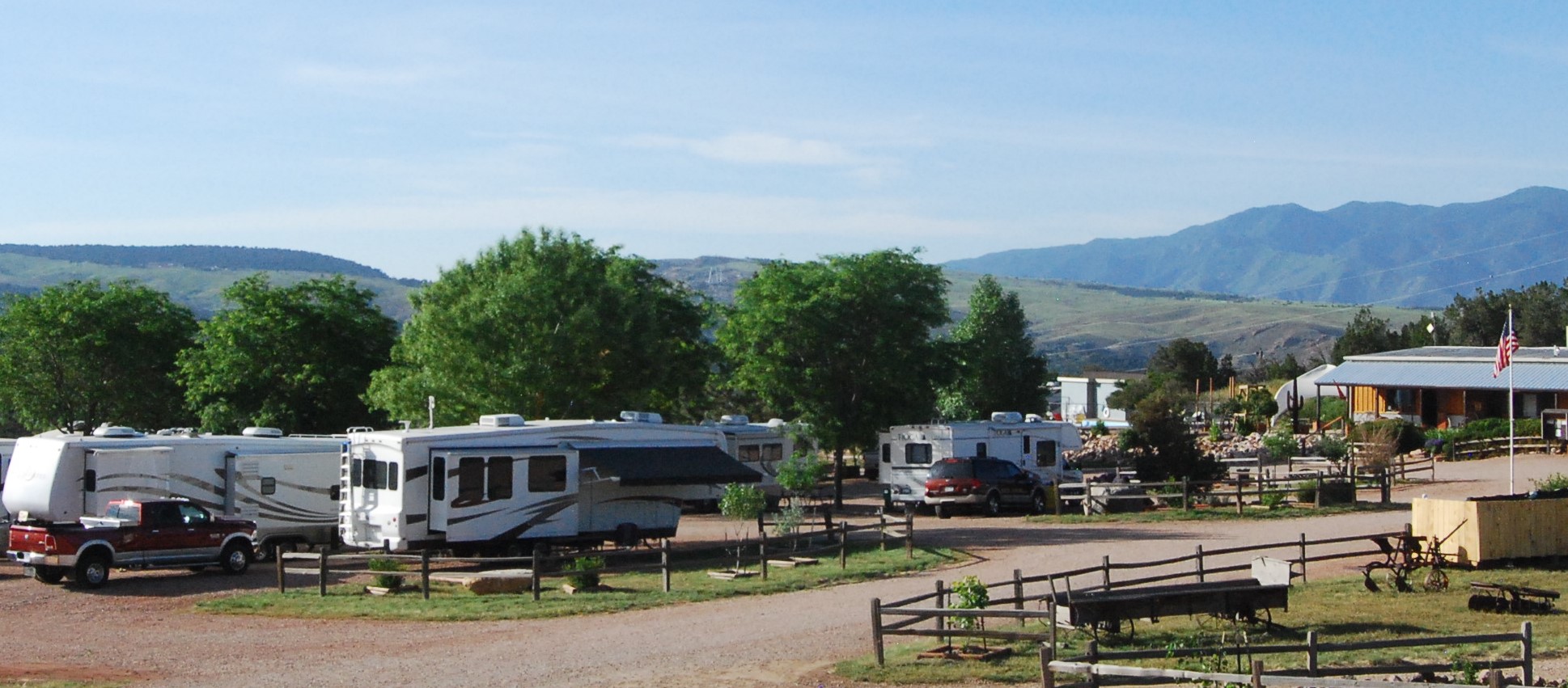 the picturesque mountain ranges loom in the background behind a row of bushy trees overlooking the RV park.